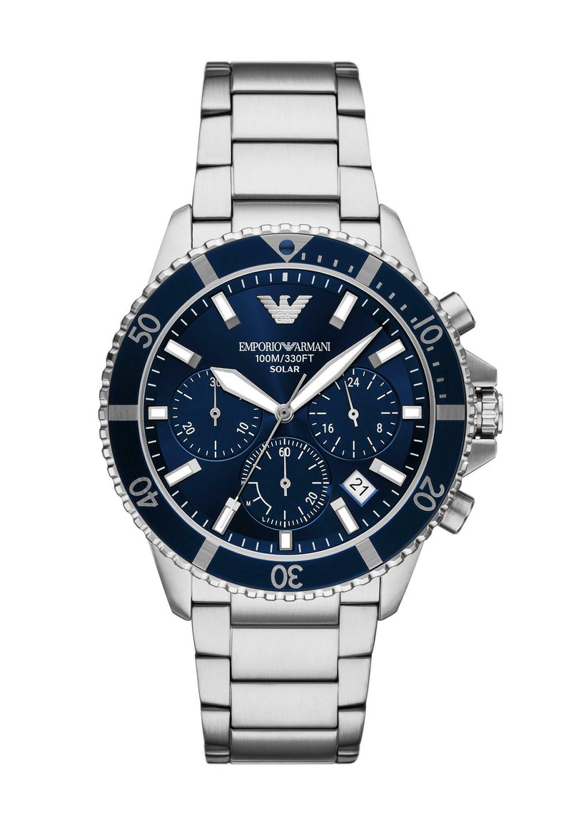 Stříbrné nerezové ocelové hodinky s modrým ciferníkem, třemi subciferníky a okénkem pro datum. Mají otočnou lunetu a solární mechanismus.