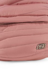 Bolso de tela acolchada en color rosa con un patrón cosido y un logo plateado. Presenta una textura suave y pequeños detalles de hardware. Forma rectangular.
