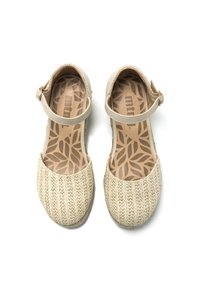 Zapatos de tela trenzada beige con correa al tobillo, punta redonda y plantilla texturizada que presenta un patrón de hojas. El material superior parece transpirable.