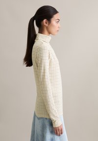 Lichtgele top met lange mouwen en coltrui, met een ruitpatroon, een getailleerde pasvorm en een zachte textuur.
