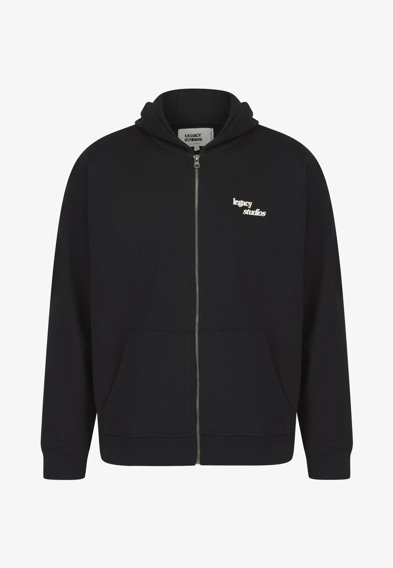 Melna rāvējslēdzēja džemperis ar kapuci no gludas auduma. Izceļas ar auklu pie kapuces, priekšējām kabatām un nelielu baltu logotipu uz krūtīm.