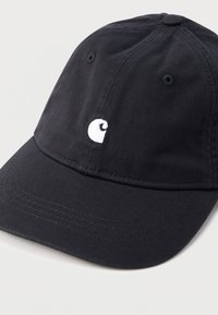 Μαύρο καπέλο μπέιζμπολ από βαμβακερό ύφασμα, με καμπυλωτή γείσο, κεντημένο λευκό λογότυπο και οπές αερισμού. Ομαλή υφή.