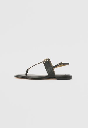 Sorte lærflat sandal med et minimalistisk design, T-stropp-silhuett, gullfargede detaljer og en smal ankelstropp.