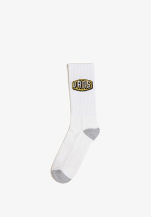 Weißer Crew-Socke mit geribbelter Textur, ausgestattet mit einem gelben und schwarzen Vans-Logo im oberen Teil und einer grauen verstärkten Ferse und Spitze.