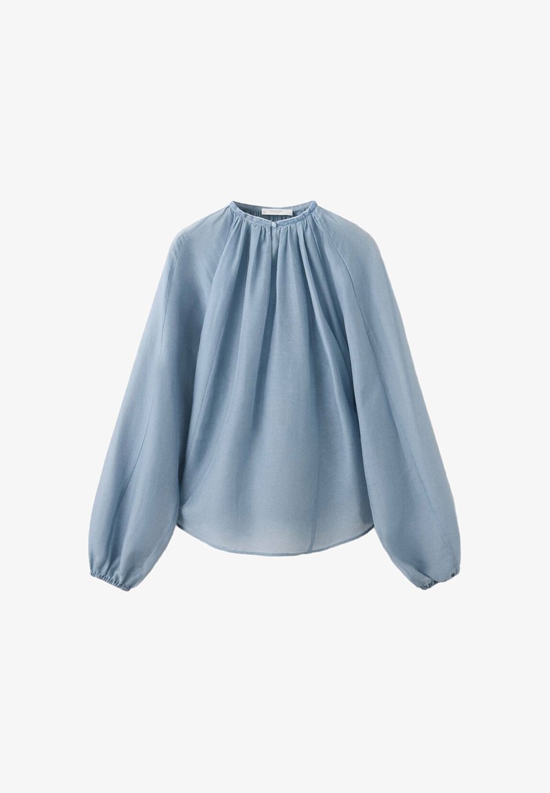 Blouse bleu clair à manches longues avec encolure froncée et poignets élastiques, fabriquée en tissu léger légèrement transparent.