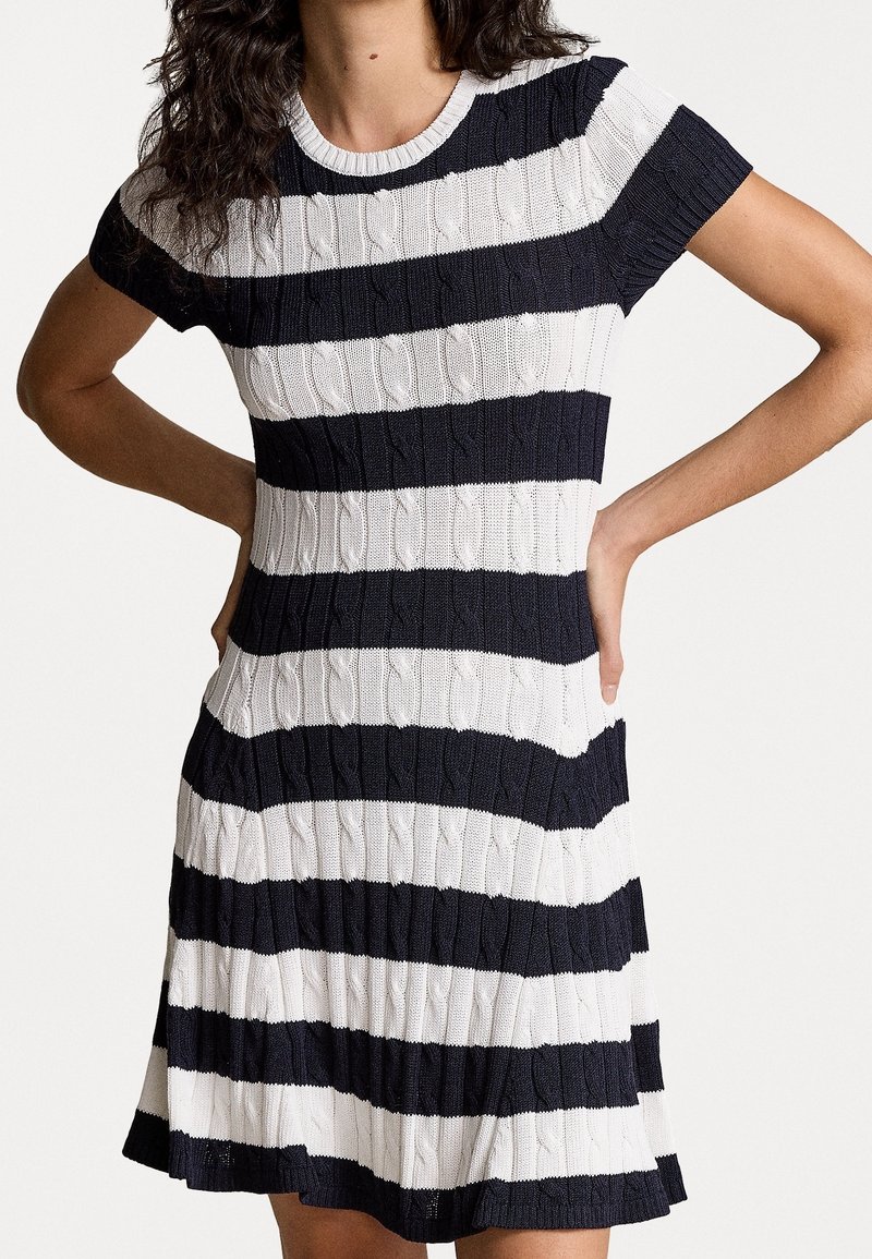 Stickad klänning med horisontella marinblå och vita ränder, med ett texturerat kabelmönster, korta ärmar och en utsvängd nederdel.