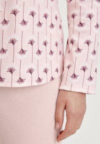 Lange mouwen top in lichtroze met een bloemenpatroon in donker bordeaux. Zachte stof met een gladde textuur, manchet mouwen en een aansluitend ontwerp.