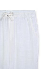 Pantaloni bianchi in lino con elastico in vita e dettaglio a fiocco, dotati di due tasche laterali e realizzati in un tessuto leggero e testurizzato.