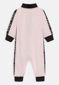 Helles rosa Baby-Overall mit langen Ärmeln, schwarzen Kragen und Bündchen, schwarzen Seitenstreifen mit weißem "Jordan"-Text.