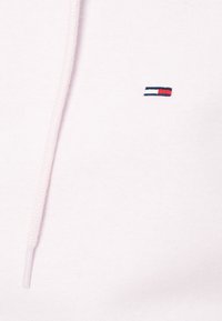 Jasnoróżowa bluza z mieszanki bawełny, z przednią kieszenią i białym sznurkiem. Małe haftowane logo w kolorach czerwonym, białym i niebieskim.