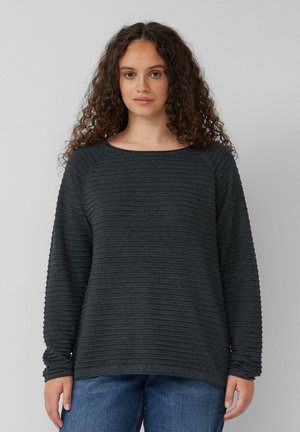 Haut à manches longues gris foncé avec une texture côtelée, encolure ronde et coupe décontractée. Associé à un jean bleu pour un look décontracté.