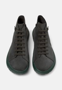 Scarpe in pelle grigio scuro con un design elegante, caratterizzate da punta tonda, lacci frontali e suola verde a contrasto. Stile minimalista con superficie liscia.
