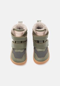 Grüne High-Top-Stiefel mit Klettverschlüssen, bekannt für das Innenfutter aus Wildleder, Gummisohlen und ein strukturiertes Stoffdesign.