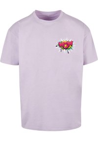 Camiseta de algodón lila con un gráfico multicolor de "WOW" y un diseño de explosión estilo cómic en la parte izquierda del pecho. Mangas cortas.