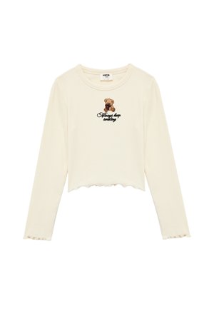Cremefarbener Langarm-Crop-Top mit gewelltem Saum, versehen mit einem Bären-Graphic und dem schwarz gestickten Schriftzug "Always keep smiling". Strukturierter Rippstoff.