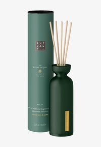 Diffuseur en céramique verte avec texture cannelée, accompagné d'un conteneur cylindrique vert. Comprend des tiges en bois pour la diffusion des fragrances.