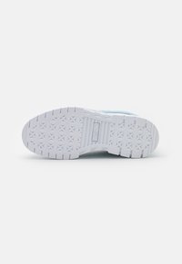 Light blue sneaker with textured fabric upper, white rubber sole featuring geometric tread pattern, and prominent logo detail on the midsole.
