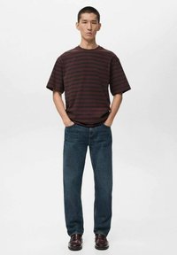 Maroon and dark gray striped short-sleeve shirt, relaxed fit, paired with blue denim jeans and burgundy shoes. Simple, casual outfit design.