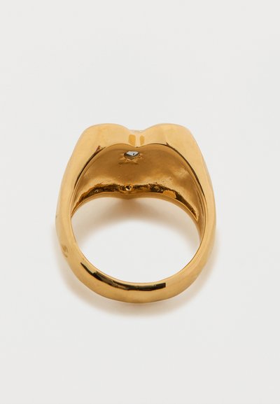 Anello d'oro con superficie liscia e lucida e design arrotondato. Presenta una piccola pietra incastonata sul lato interno.