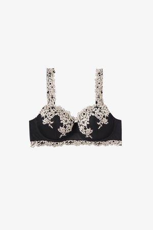 Soutien-gorge noir avec superposition de dentelle florale beige sur les bonnets, les bretelles et le bandeau, offrant un soutien armaturé et un bord en dentelle festonné.