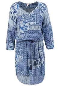 Robe bleue à motifs avec manches longues, décolleté en V, taille cintrée et accents de franges. Fabrication en tissu léger présentant un mélange de motifs floraux et géométriques.