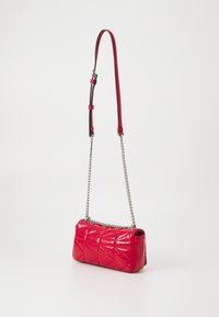 Borsa a tracolla in pelle trapuntata rossa con catena e tracolla in pelle. Forma rettangolare con superficie testurizzata e dettagli in metallo.