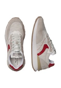 Sneaker in suede grigio chiaro con accenti rossi e lacci bianchi. Presentano una tomaia testurizzata, suola imbottita e un logo discreto sulla linguetta.