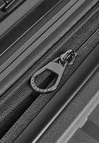 Valise noire avec une surface en tissu texturé, dotée d'une tirette de fermeture éclair élégante gravée de "EXPANDABLE" et d'une finition matérielle noire lisse.