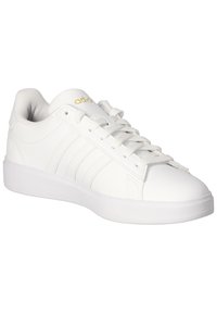 Biele športové topánky s hladkým syntetickým vrchom, tromi embosovanými pruhmi a polstrovanou bielou podrážkou. Zlatoznačkovanie na jazyku.