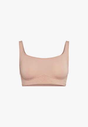 Reggiseno color pelle con una texture liscia, spalline larghe e design senza cuciture. Presenta una leggera costina lungo il bordo inferiore.