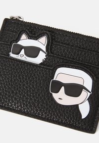 Black textured cardholder featuring two cartoon icons: a cat and a person, both wearing sunglasses, with prominent accents and a zip closure.