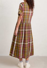 Krátký rukáv, midi šaty v mnohobarevném kostkovaném vzoru s odstíny hnědé, růžové a šedé, s nařaseným pasem a splývavou sukní.