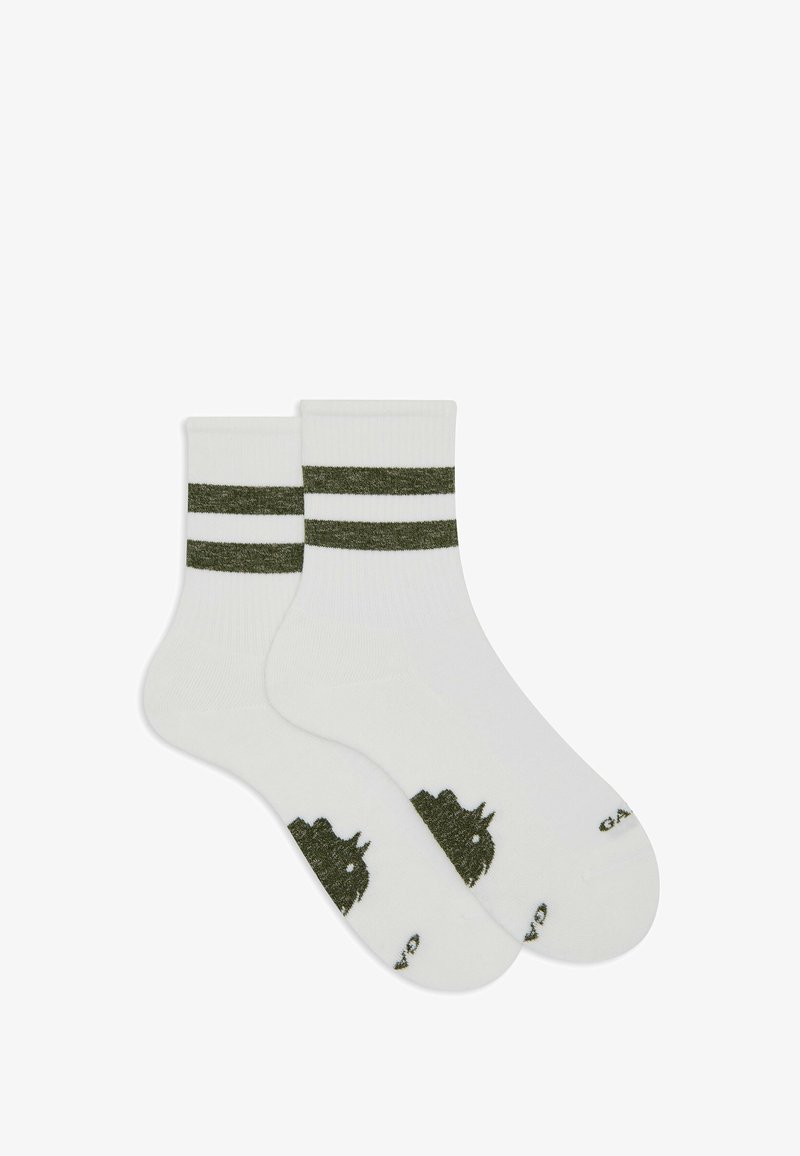 Calze bianche con strisce verdi nella parte superiore, caratterizzate da un design testurizzato e una grafica verde scuro sulla suola. Realizzate in un materiale morbido.