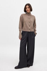 Bruine wolmix cropped cardigan met hoge kraag, knoopsluiting en geribbelde manchetten, gecombineerd met grijze hoge taille wijde pijpenbroek.