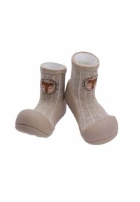 Zapatitos para bebé en suave color beige con suelas de goma y parte superior tipo calcetín, que presentan un bonito diseño de cara de ciervo en la parte delantera.
