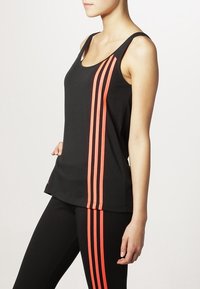 Top nero senza maniche con tre strisce corallo verticali sul lato sinistro, realizzato in un tessuto liscio e leggero, con scollatura a barchetta.