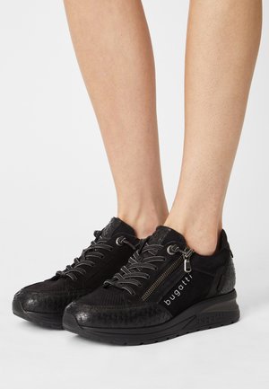 Schwarze Schnürsneaker mit einem Reißverschlussdetail, einer Mischung aus glatten und geprägten Materialien sowie einem Logo-Druck an der Seite.