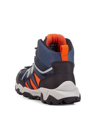 Mittelhohe Wanderschuhe mit einem navyfarbenen Obermaterial und orangefarbenen Akzenten, einer strukturierten schwarzen Ferse und einer robusten grauen Sohle für besseren Grip.