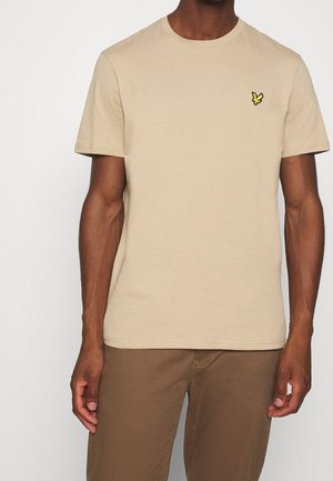 Beige cotton t-shirt featuring a round neck, short sleeves, and a small yellow logo on the chest. Smooth texture, casual fit.