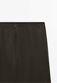 Jupe taille haute marron foncé avec une fermeture éclair dissimulée au dos et des détails subtils de coutures verticales.