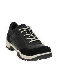 Zapato negro de cordones hecho de cuero y ante, con suela acolchada y una textura en la suela. Los cordones y la costura en gris realzan el diseño.