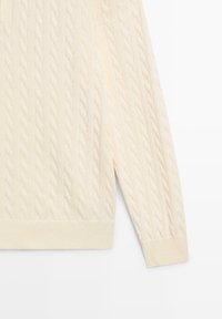 Kremowy sweter z dzianiny warkoczowej z prążkowanymi mankietami i wykończeniem dolnym. Wzór o fakturze prezentuje spleciony design, wykonany z miękkiej, elastycznej dzianiny.