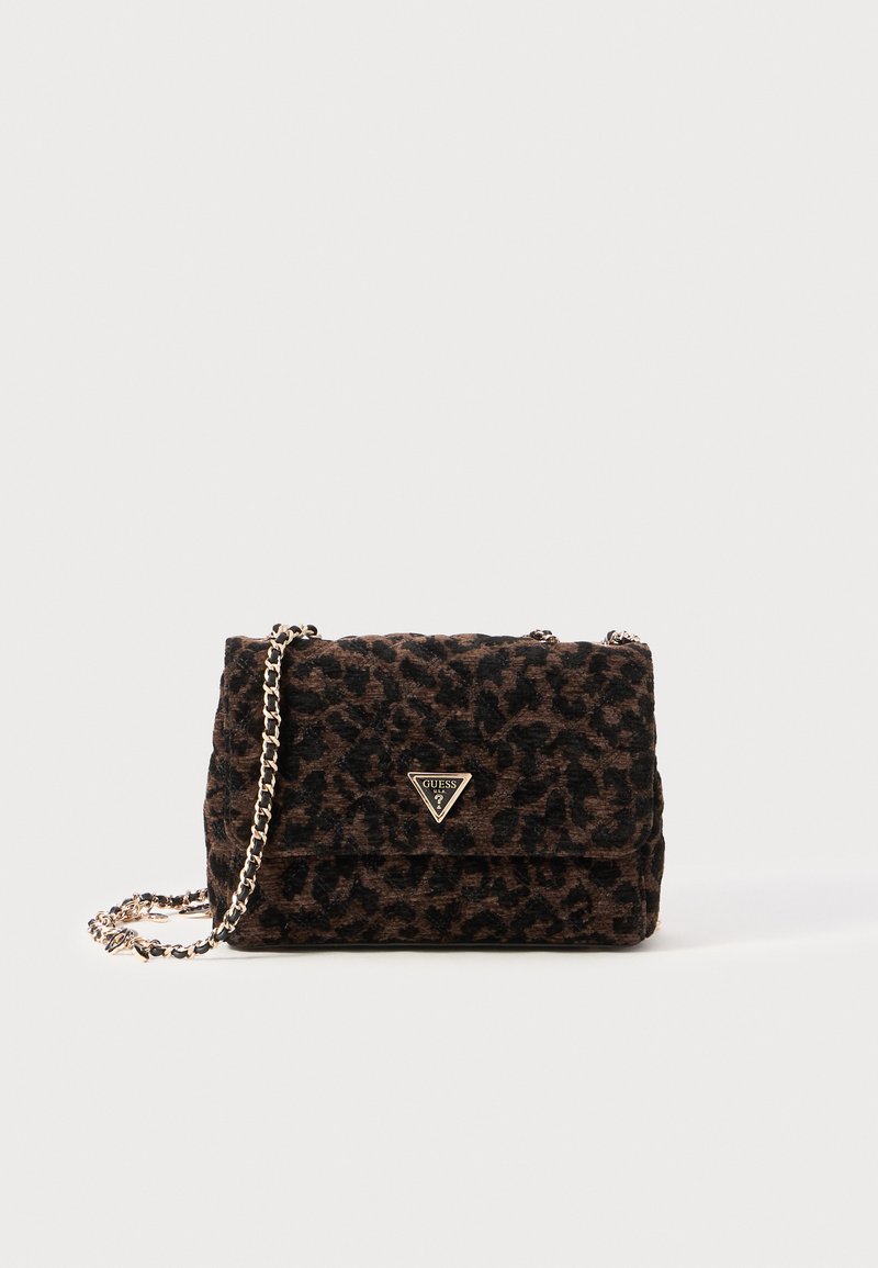 Pequeño bolso de hombro con estampado de leopardo en marrón y negro, con correa de cadena dorada y logotipo triangular de Guess en la solapa frontal.