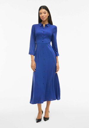 Robe à manches longues, boutonnée en tissu satin bleu vif. Présente une taille cintrée et une jupe évasée, avec une texture lisse et brillante.