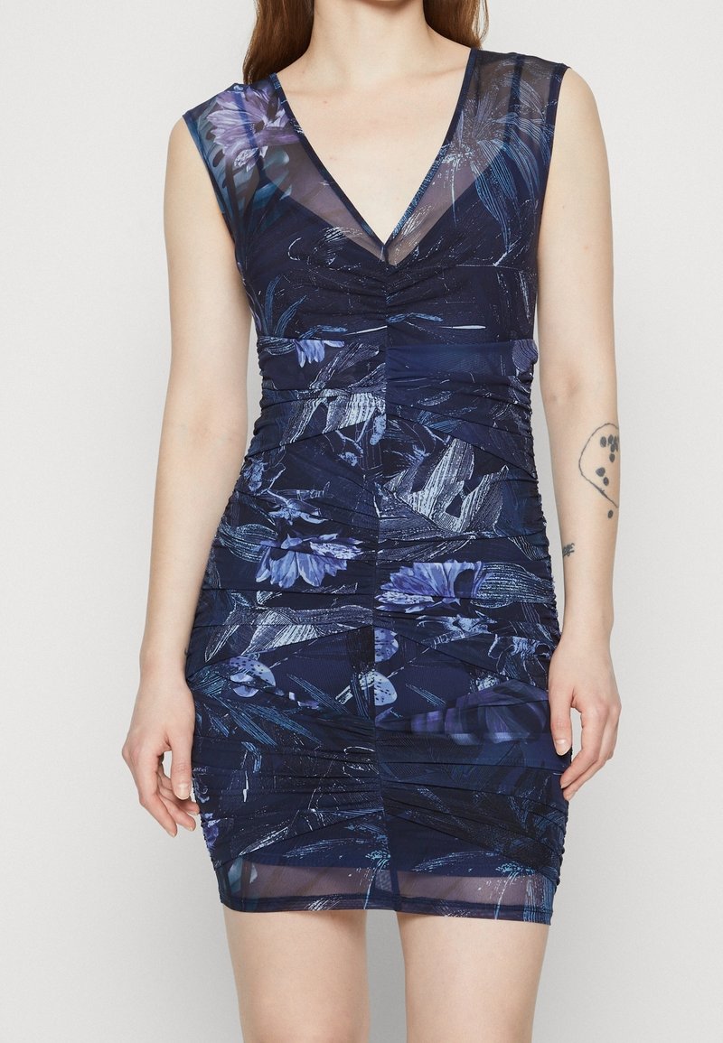 Robe florale bleu marine avec un col en V et une coupe sans manches. Présente des détails froncés et un tissu texturé avec une superposition transparente.