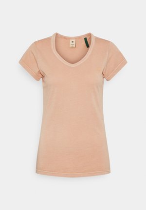 Helles Pfirsichfarbenes V-Ausschnitt-T-Shirt mit kurzen Ärmeln, aus weichem Material. Verfügt über eine minimale Markenkennzeichnung in der oberen linken Ecke.