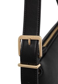 Tracolla per borsa in pelle nera con fibbia e dettagli in metallo dorato. Presenta un design elegante e un dettaglio di cerniera visibile sulla borsa.