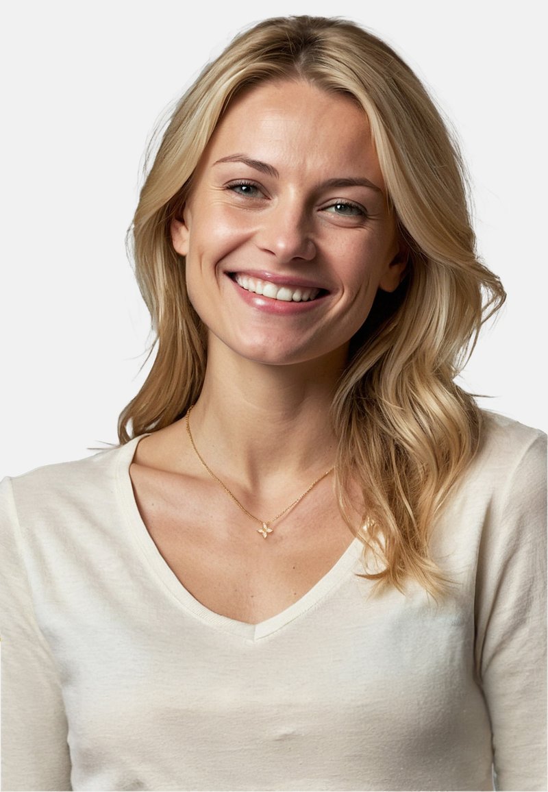 Femme blonde souriante, portant un t-shirt beige clair à col en V. Un délicat collier en or avec un petit pendentif en forme de papillon est visible.