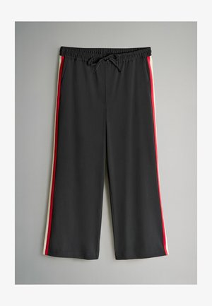 Schwarze Hose mit elastischem Bund und Kordelzug, mit roten und weißen Seitenstreifen. Hergestellt aus glattem, leichtem Stoff.