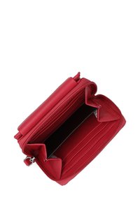 Červená kožená peněženka se zipovým uzávěrem. Obsahuje několik přihrádek na karty a další oddělení, má hladký povrch a minimalistický design.